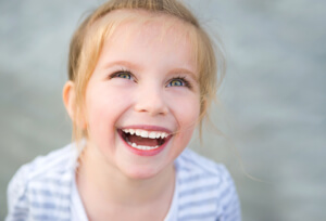 little girl uses tools behind conversations and laughs