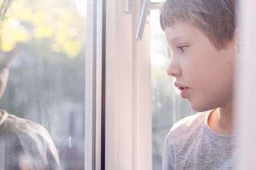 boy looking out window needs treatment for children with autism spectrum disorder