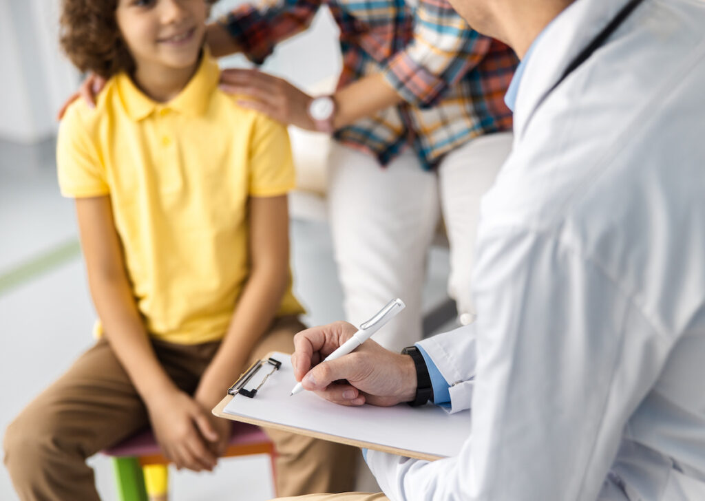 Physician is filling form about boy health stock photo Physician is filling form about boy health stock photo