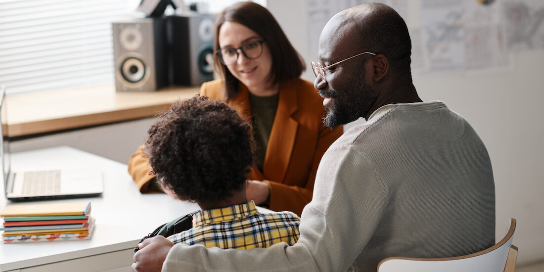 Father talking to teacher in classroom